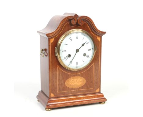 An early 20th century mahogany cased eight day mantel clock. With carved swan neck pediment, inlaid shell patera and enamel d