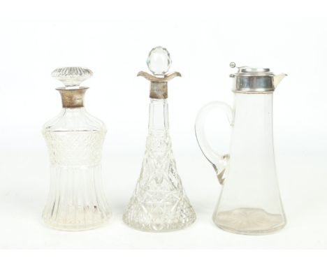 Three silver mounted glass decanters. One of waisted form and having mushroom stopper assayed Birmingham 1935, a Victorian ta