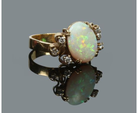 An 18 carat gold, diamond and opal ring of abstract form. Set with six diamonds flanking the large ovoid central opal. Size P