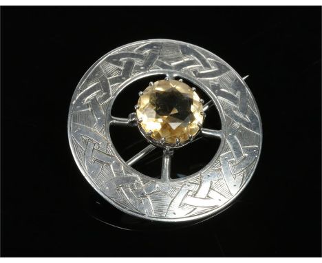 A Scottish provinacial silver roundel brooch. Set with a pale citrine and engraved with Celtic knots. Punch marks for J. K. &