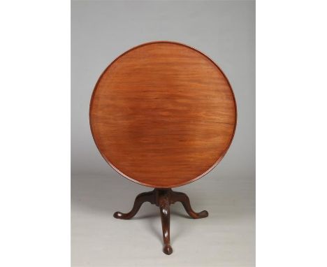 A Georgian mahogany snap top supper table. The dished top rotates on a bird cage mechanism, raised on a tripod base and with 