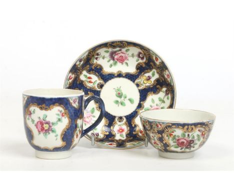 A Worcester teacup, tea bowl and saucer. Scale blue ground and with gilt framed panels painted in coloured enamels with Europ