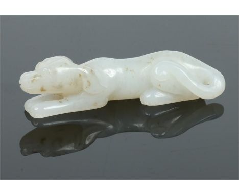 A 19th century Chinese small white jade carving formed as a recumbent dog with charcoal suffusion, 6cm.Condition report inten