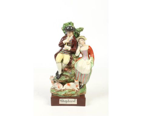 A 19th century pearlware figure group modelled as a shepherd and his companion and coloured in enamels. Seated before a bocag