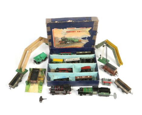 A collection of clock work tinplate 0 gauge model railway. Including two boxed Hornby sets, other engines, carriages, rolling
