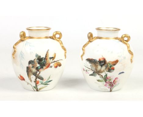A pair of Victorian Royal Worcester ovoid vases. Each with three moulded scrolling serpent handles decorated in gilt. Moulded