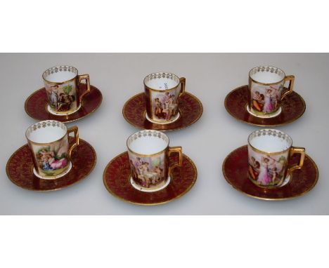 A set of six early 20th century Vienna porcelain coffee cans and saucers, each figurally decorated after Kaufmann on a deep r