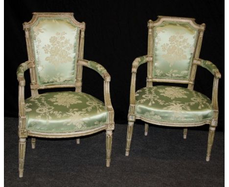 A pair of 19th century French open armchairs, each having caddy rail, padded bow back, overstuffed seat, on turned fluted for