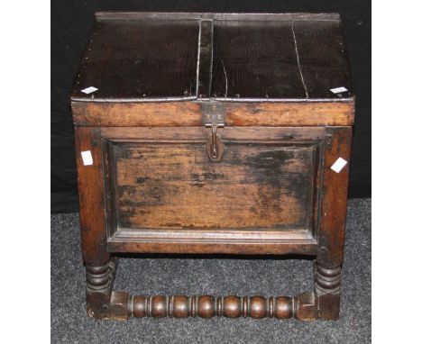 An 18th century oak bible box, the hinged plank top over panel sides with twin brass handles on turned supports united by a b