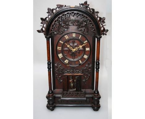 A late 19th century Black Forest mantle clock of large proportions, the dome top leaf carved case enclosing a gong striking m