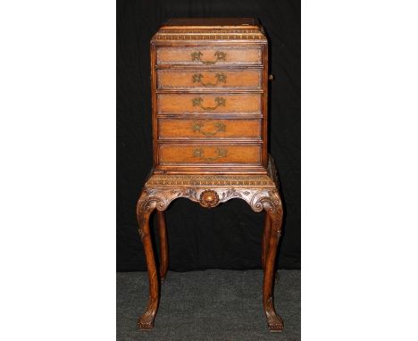 A reproduction burr walnut veneer chest on stand of small proportions, the caddy top over egg and dart frieze and five drawer