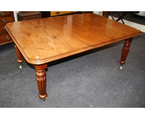 A William IV mahogany extending dining table, the rectangular top and three inset leaves with moulded edge, on turned reeded 