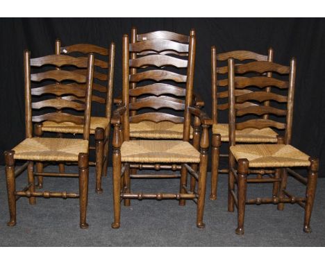 A set of six reproduction elm ladder back dining chairs, each with woven rush seat, on turned forelegs and pad feet united by