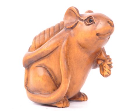 A 20th century Japanese wood good fortune netsuke. The netsuke being carved in the form of a mouse carrying money on its back