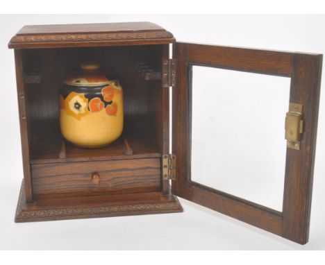 A mid 20th century circa 1940s mahogany wood tobacco / smokers cabinet. The cabinet having a plinth base with carved geometri