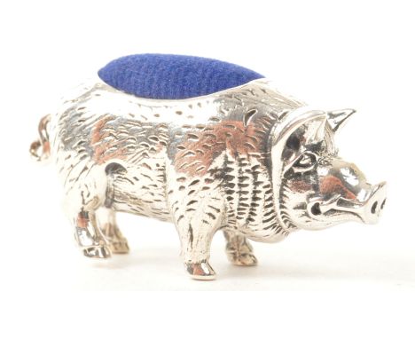A vintage 20th century silver pin cushion in the form of a pot belly pig. Pig in a standing position with blue felt cushion a