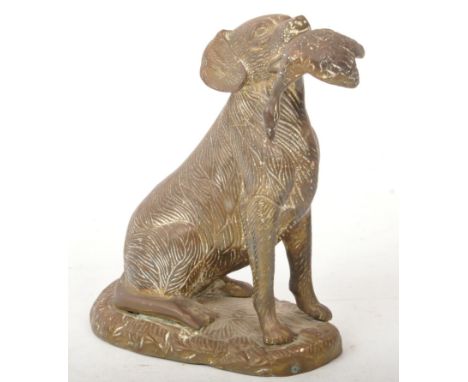 A 19th century brass hunting dog statue figure. The figure in a seated position, raised on a naturalistic base with repousse 