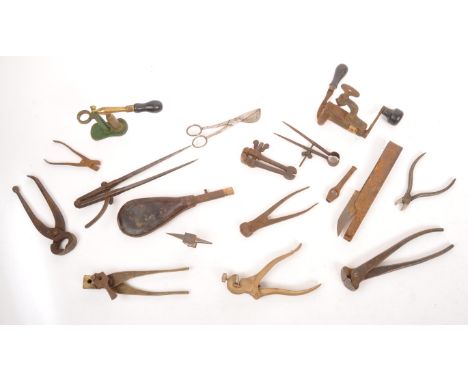 A collection of vintage 20th century gunsmiths equipment. Cast iron material with squeeze bag, bullet tools, axis, compasses 