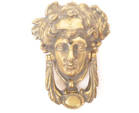 A 19th Century Victorian brass door knocker in the form of Greek God / Grecian face with leaves to head and flourishes / scro