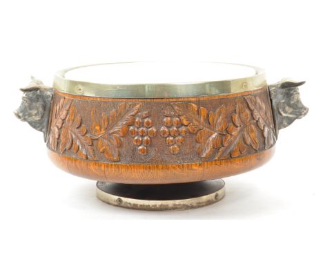 A mid 20th century carved oak and ceramic salad serving bowl. The bowl raised on a rounded pedestal stand, with silver plated