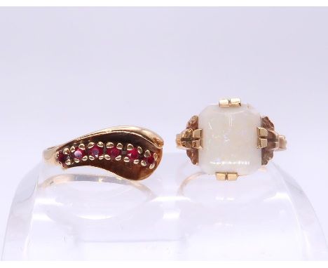 A 10k gold Art Deco ring set with a white opal, size N1/2, together with a red gem set yellow metal ring, size N1/2, weight t