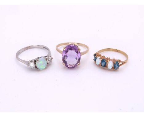 An 18ct white gold opal and clear gem set ring, size S, weight 3.4gms, a yellow metal mounted amethyst ring, size T, weight 2