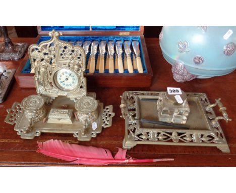 Pierced brass inkstand with glass inkwell and another with two inkwells and ornate clock to back