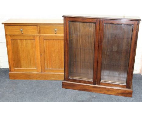 An Edwardian light oak cupboard, the rectangular top over two frieze drawers with brass drop handles and a pair of doors, on 