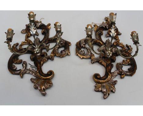A pair of 20th century Rococo form carved wood, metal and parcel gilt three light wall sconces, 60cm high