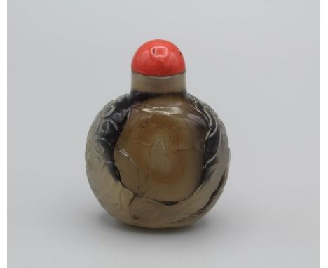 Snuff Bottle. Chalcedony of rounded rectangular form with a small oval base, carved in low relief with a continuous design of