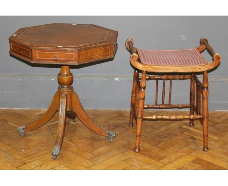 A reproduction mahogany lamp table, the tooled hide set rectangular top over four frieze drawers, on a baluster column, four 