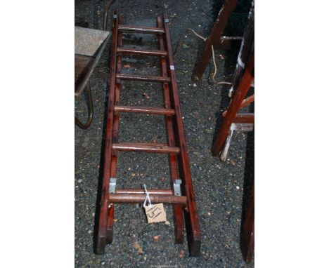 A 6 rung wooden extension ladder without metal safety bars for decorative purposes only.