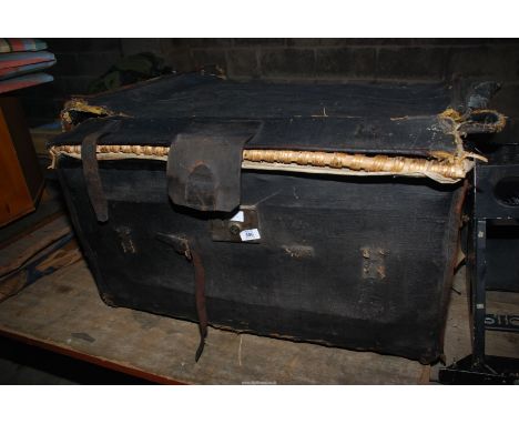 A bound wicker trunk with leather straps.