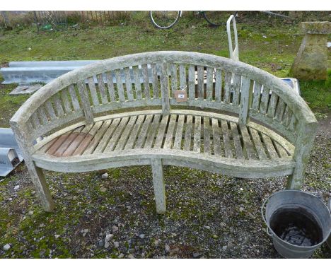 A curved Teak garden bench.