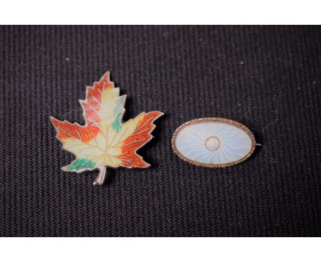 A sterling silver and enamel leaf brooch; silver and enamel oval brooch