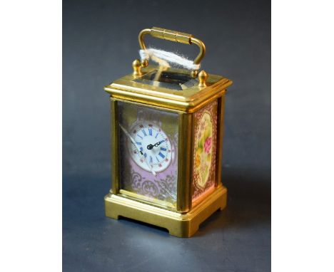 A  French miniature gilt brass carriage clock, the porcelain panels painted with flowers on a rose pompadour ground, swing ha