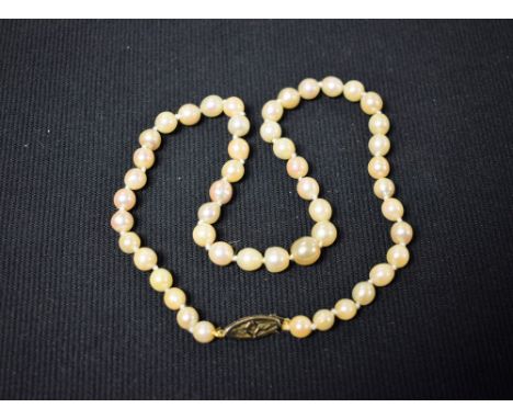 A single strand cultured pearl necklace, uniform sized irregular pearls individually knotted, united by a seed pearl set 18ct
