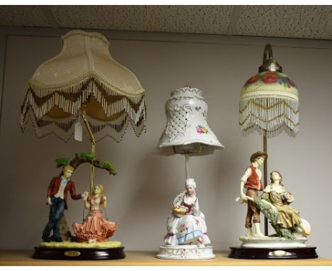 A Juliana Collection table lamp, in moulded resin as a courting couple, the girl seated on a swing; another as a courting cou