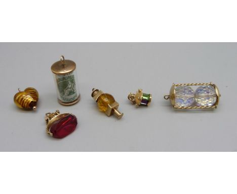 Four hallmarked 9ct gold charms, banknote, hour glass, lamp and red stone swivel, and two other yellow metal set charms, (6) 