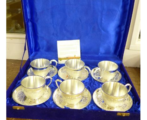 A set of six silver plate on brass teacups and saucers, by Capgemini, cased