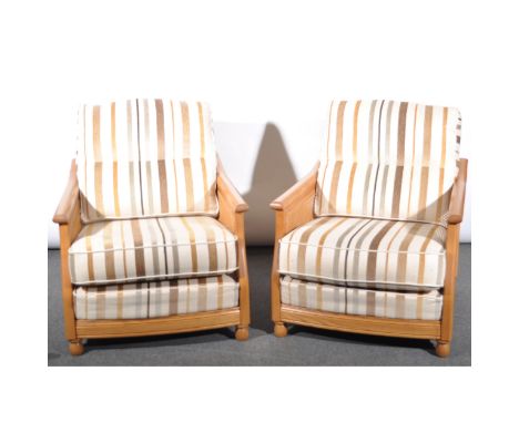 An Ercol three piece bergere suite, two seater settee and two easy chairs upholstered in a striped fabric with loose and scat