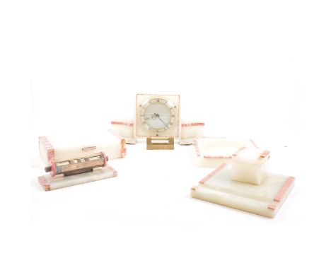 An Art Deco white alabaster and pink veined marble desk set, clock, a barrel perpetual calendar, inkstand with inkwell and pe