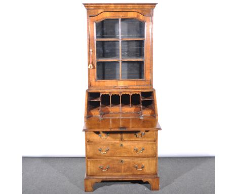 A walnut bureau bookcase, in the George I style, moulded cornice above a shaped glazed door enclosing two fixed shelves, cand