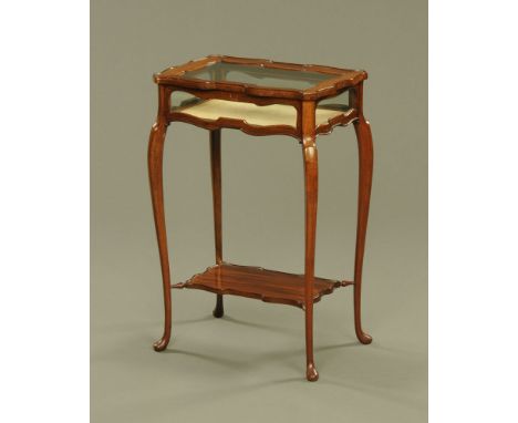 A mahogany bijouterie table, with glass top and panelled sides raised on cabriole legs united by a low shelf.  Height 68 cm, 