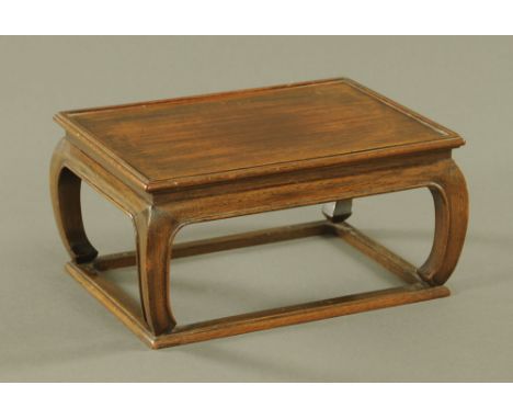A Chinese Huanghuali rectangular stand, in the form of a miniature Kang table with curved moulded legs united by stretchers. 