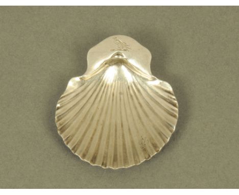 A George III silver scallop form caddy spoon by RG, London 1776, the terminal with bird armorial. CONDITION REPORT: This spoo
