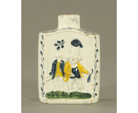 An 18th century pearlware pottery tea caddy, decorated in underglaze blue with leaves, moulded in relief and decorated in yel