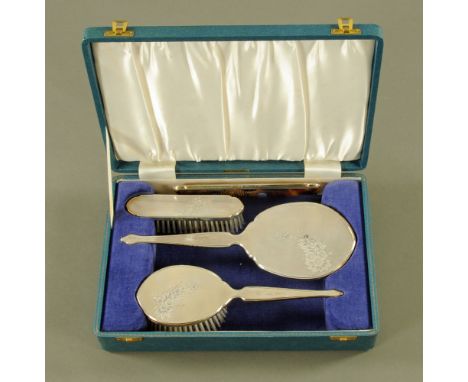 A cased silver dressing table set, in blue plush lined case, engine turned and foliate decorated, Birmingham 1967, maker Bark