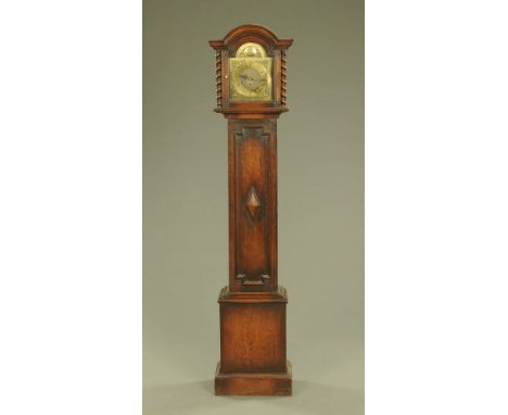 An oak grandmother clock, with arched hood and glazed door enclosing the brass dial and eight day movement striking on four g