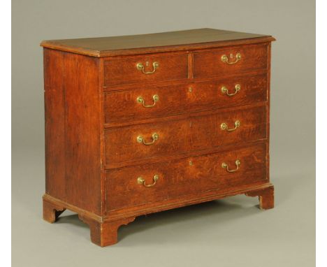 A George III mahogany banded oak chest of drawers, the moulded top above two short and three long cockbeaded drawers each wit